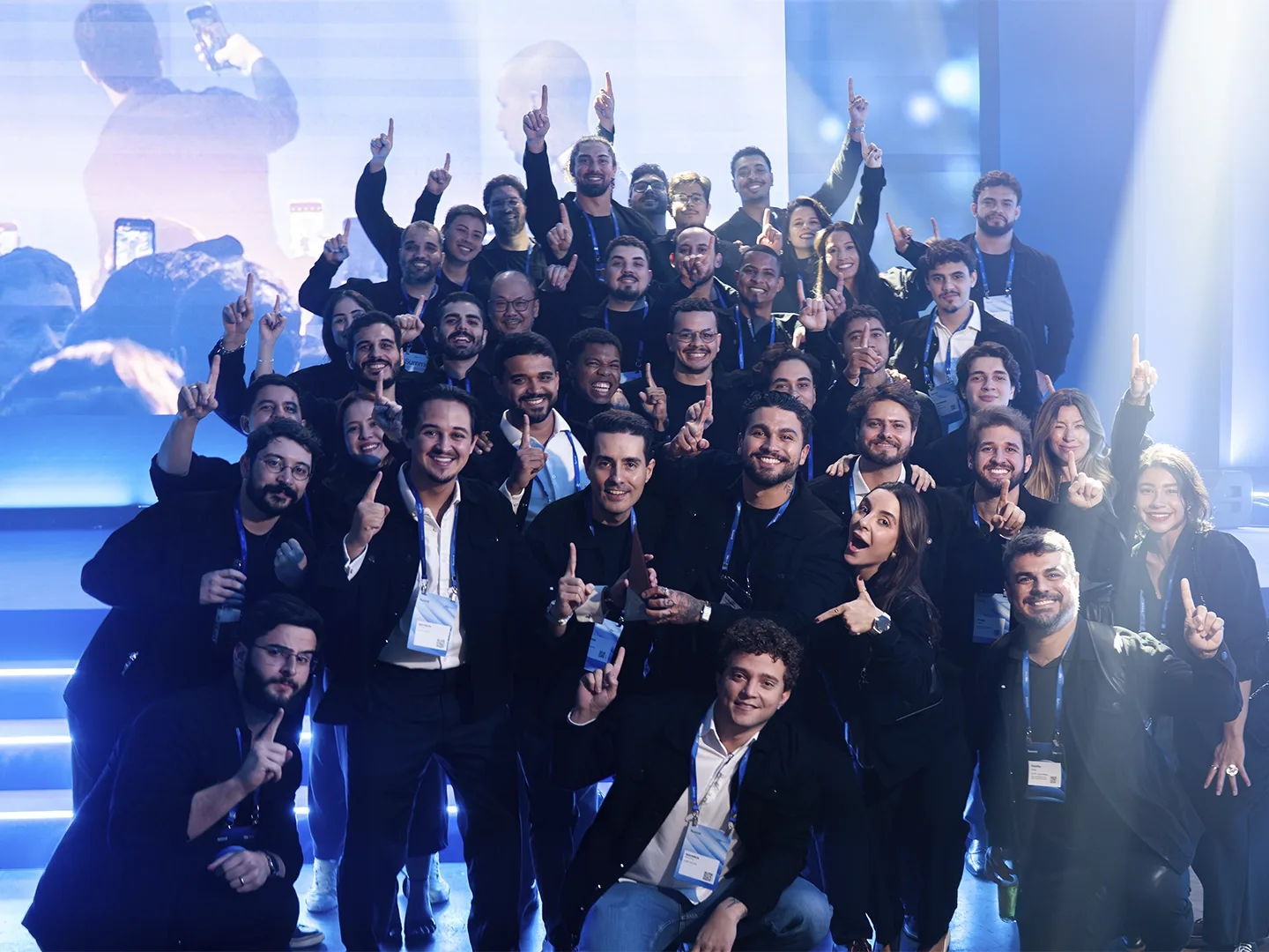 Time da AUVP Capital reunido no palco, com o gesto de número um.